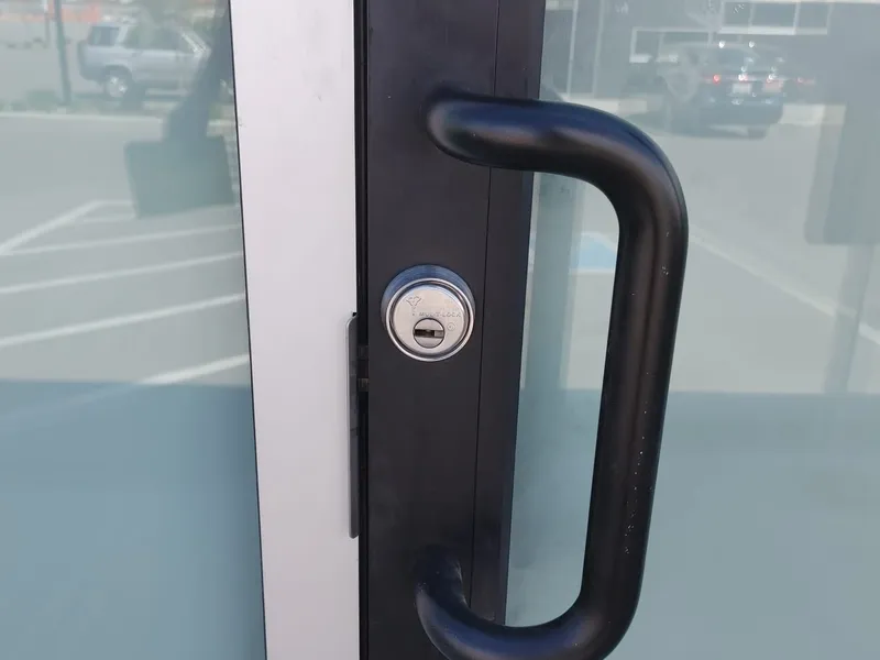 Aluminum storefront door with a black Mul-T-Lock cylinder installed
