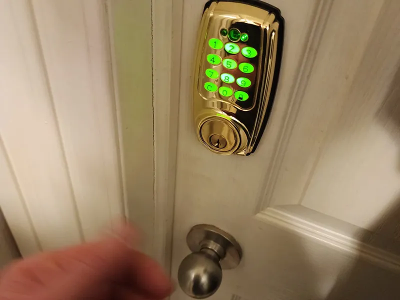 Brass keypad deadbolt with green illuminated keys