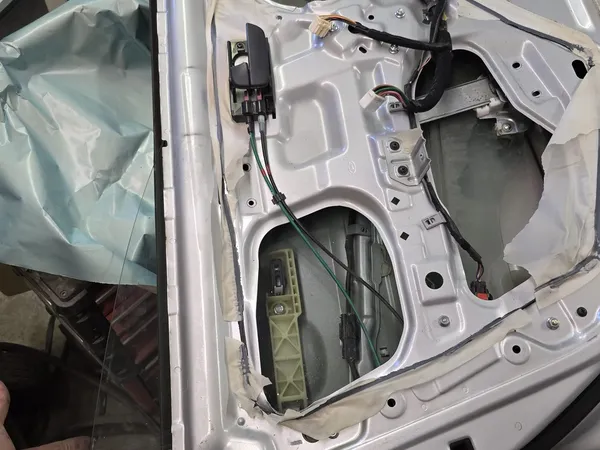 Car door interior panel removed with speaker exposed