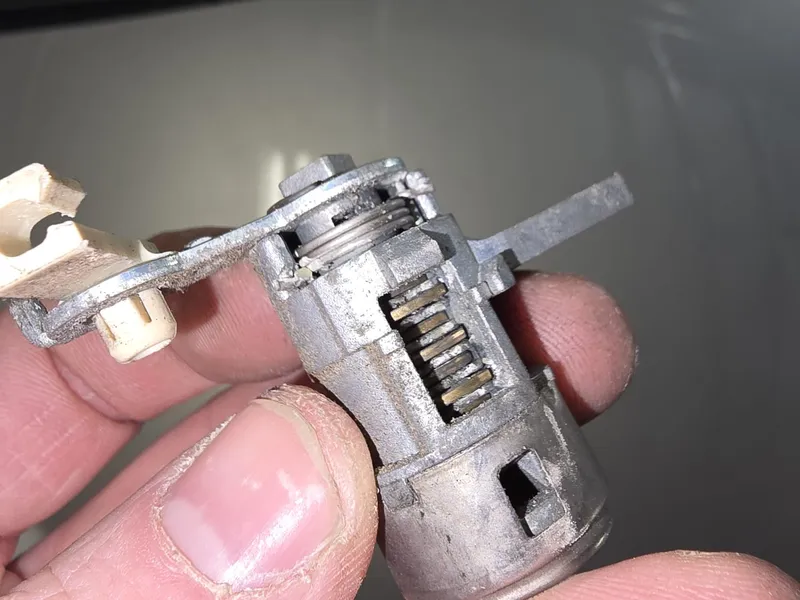 Car ignition cylinder disassembled showing internal wafers