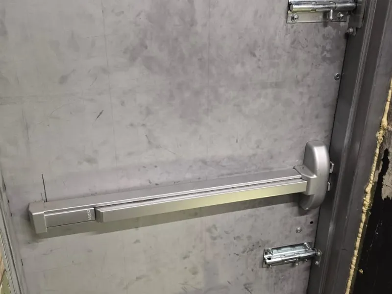 Commercial steel door with panic bar and surface bolts