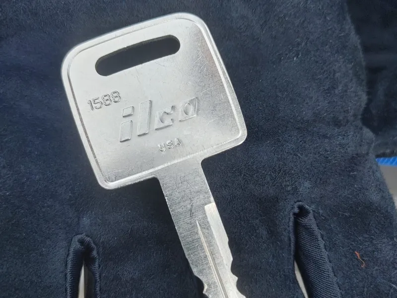 ILCO 1588 key blank on a gloved hand