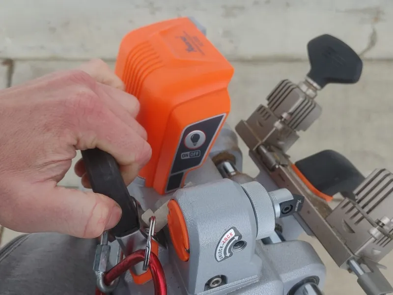 Portable battery-powered key cutting machine in use on the truck
