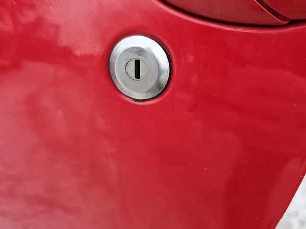Red car door lock cylinder closeup