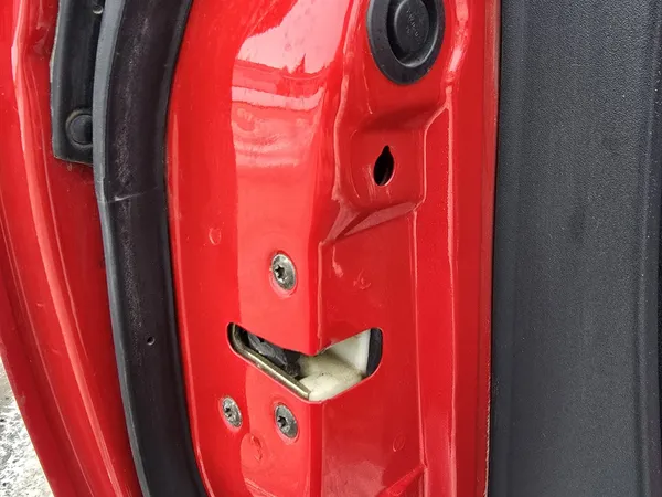 Red car door striker exposed during service