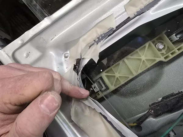 Silver car door panel disassembled for lock service