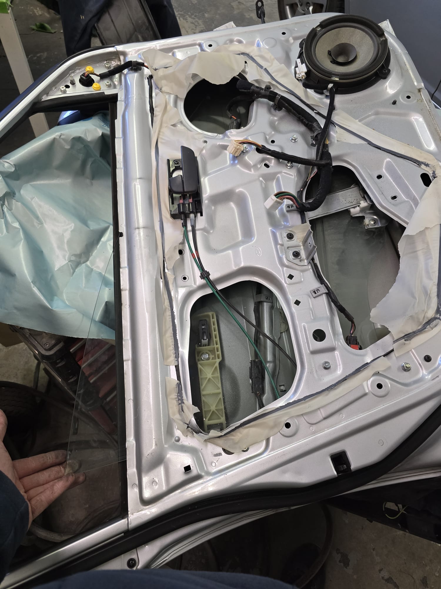 Car door interior panel removed with speaker exposed