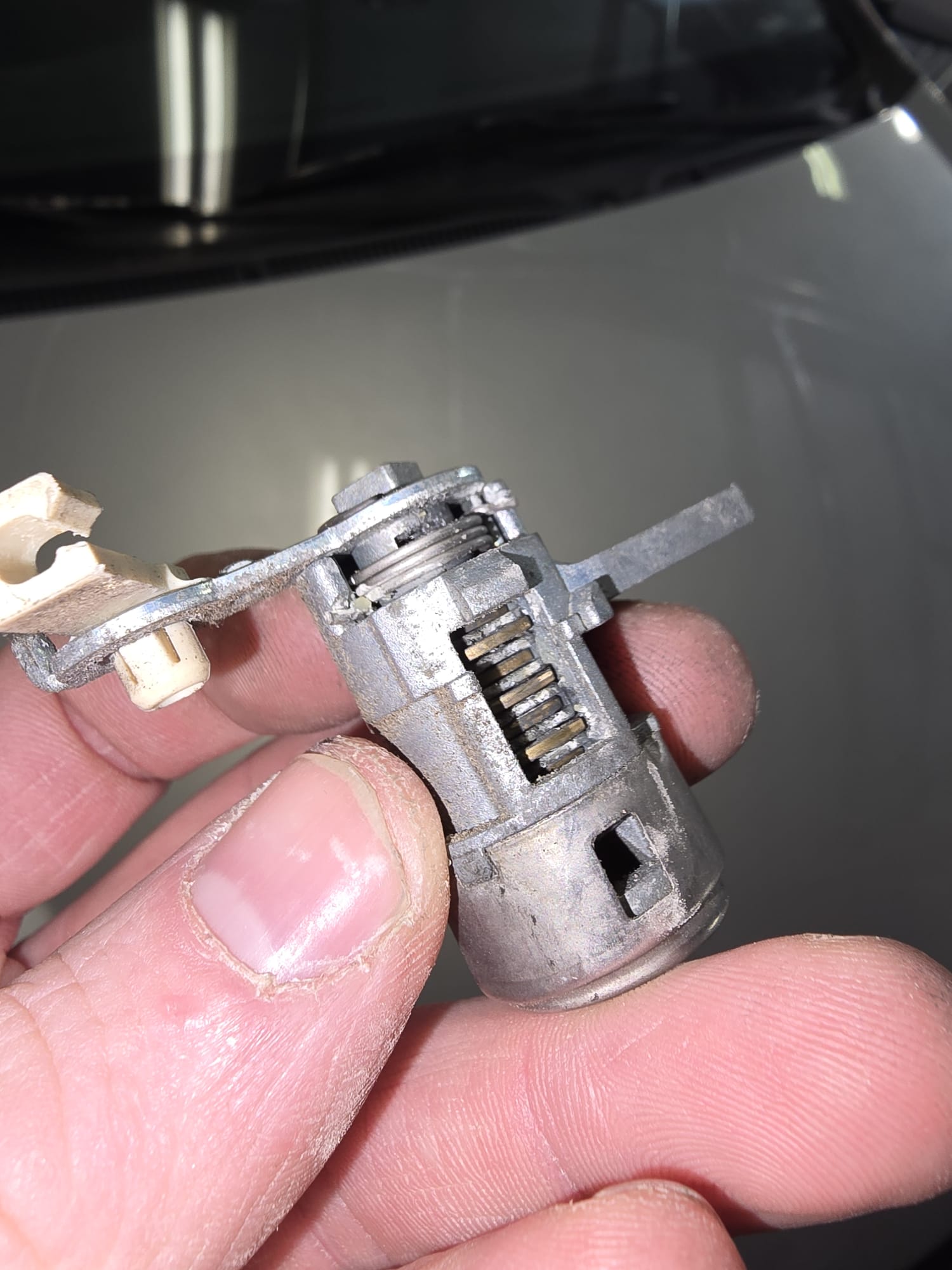 Car ignition cylinder disassembled showing internal wafers