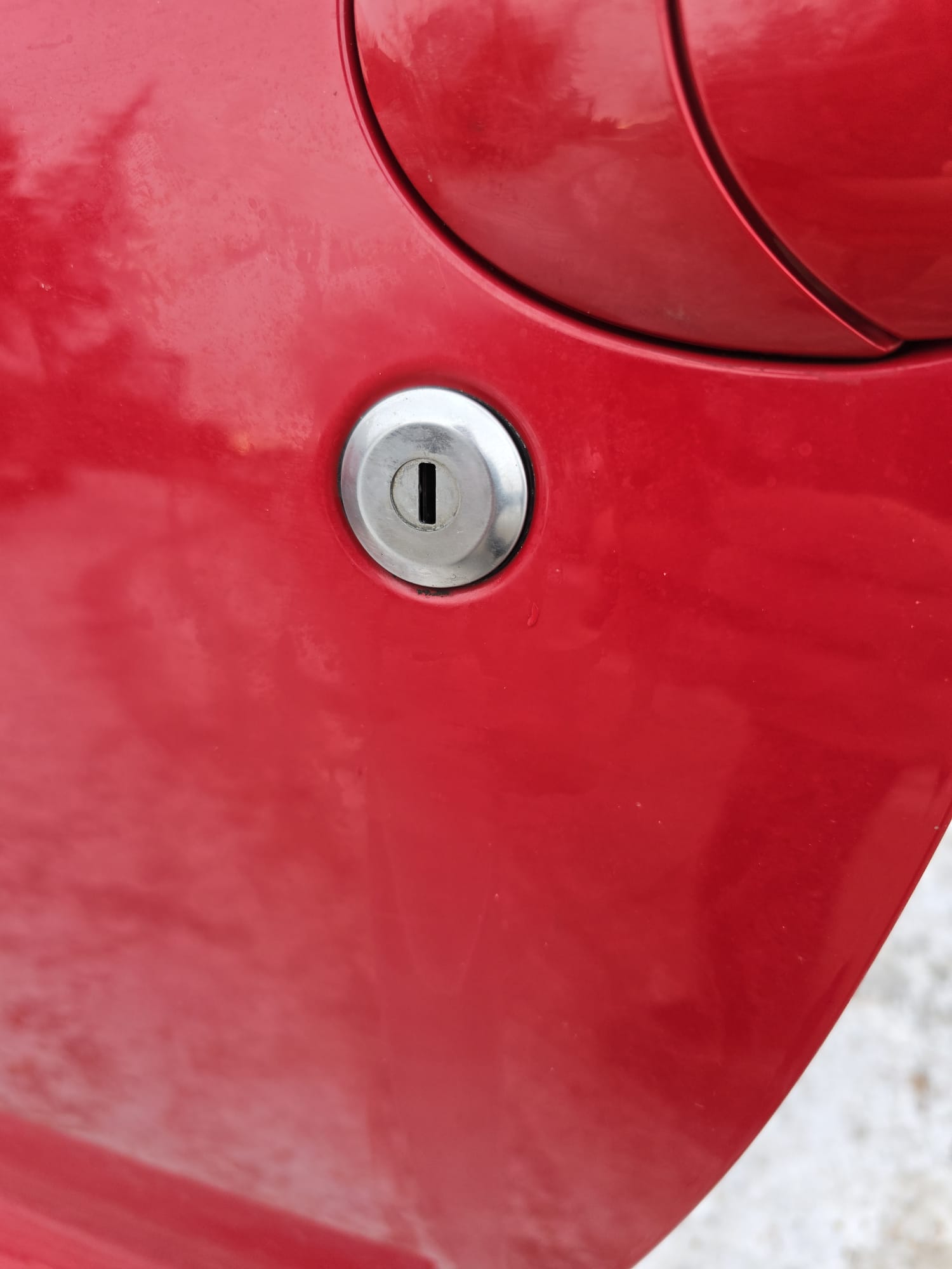 Red car door lock cylinder closeup