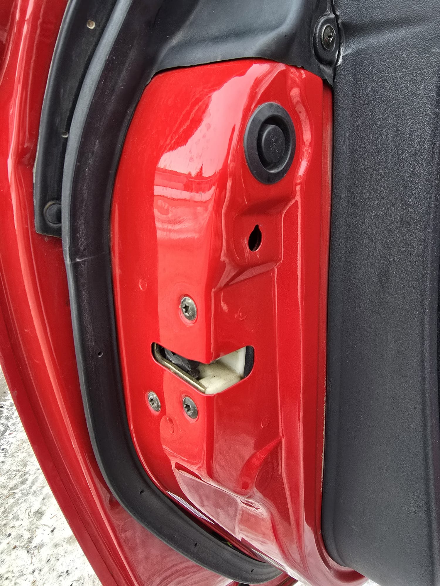 Red car door striker exposed during service