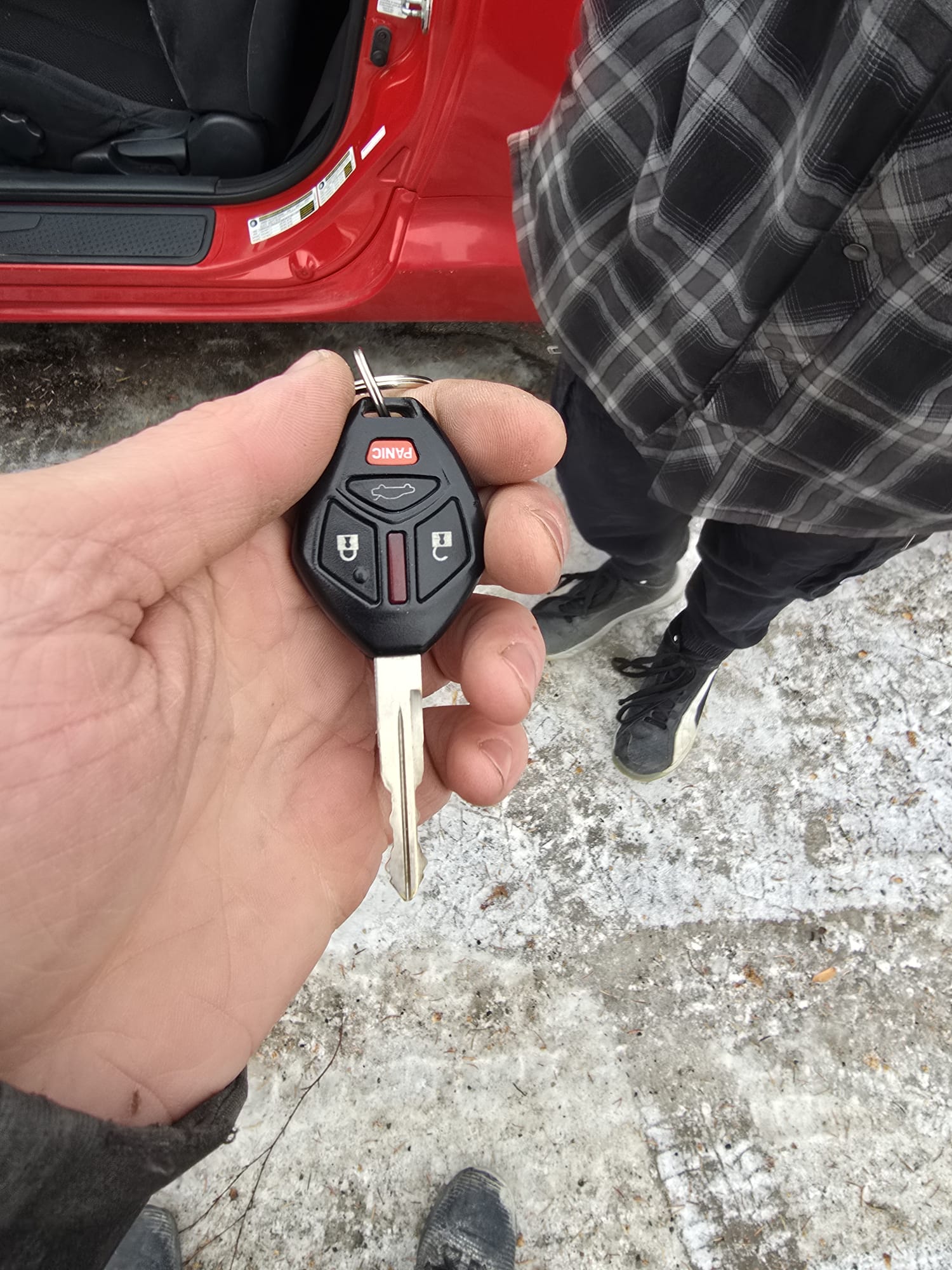 Mitsubishi key fob with a red car in the background