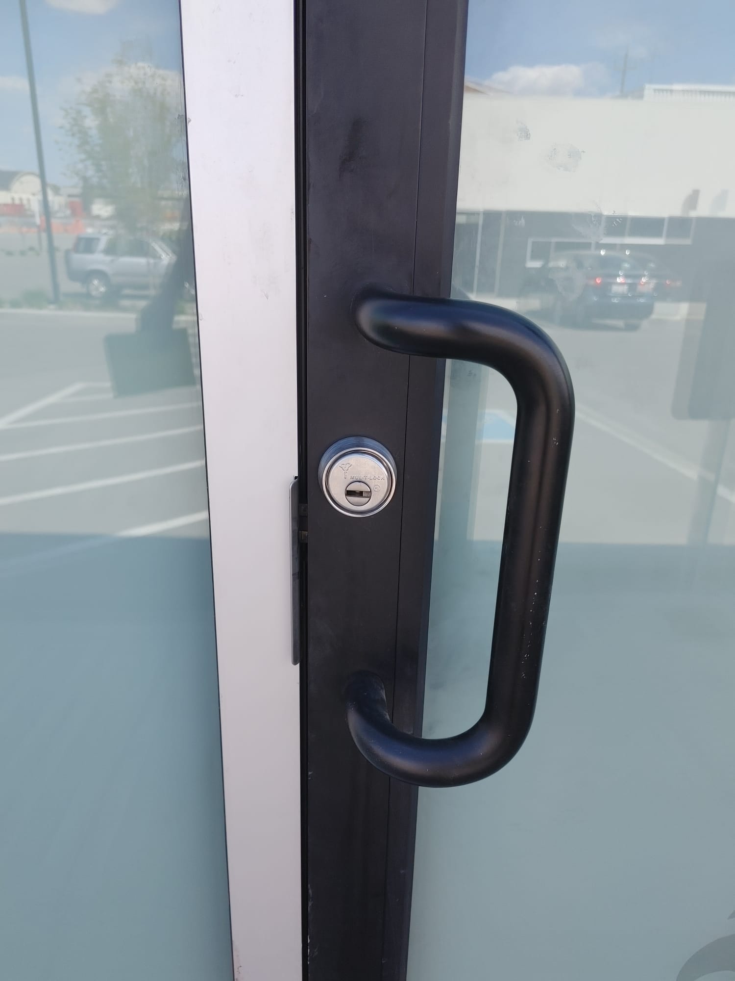 Aluminum storefront door with a black Mul-T-Lock cylinder installed