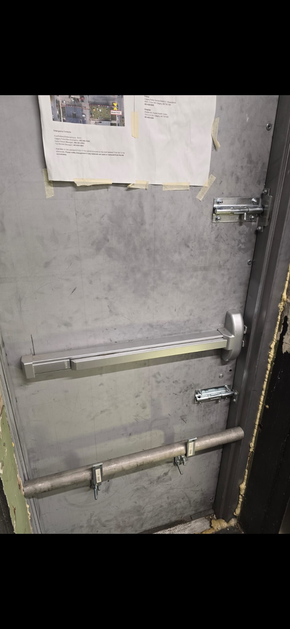 Commercial steel door with panic bar and surface bolts