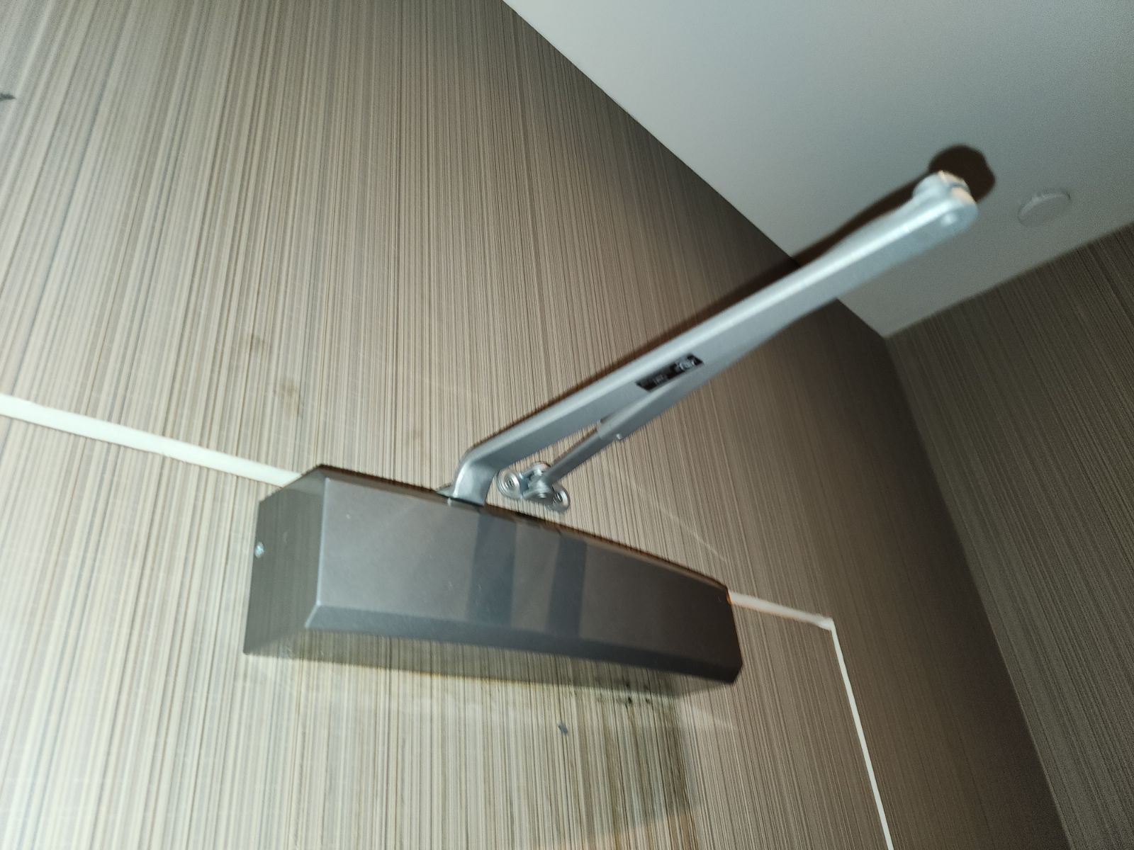 Door closer arm mounted to a commercial frame