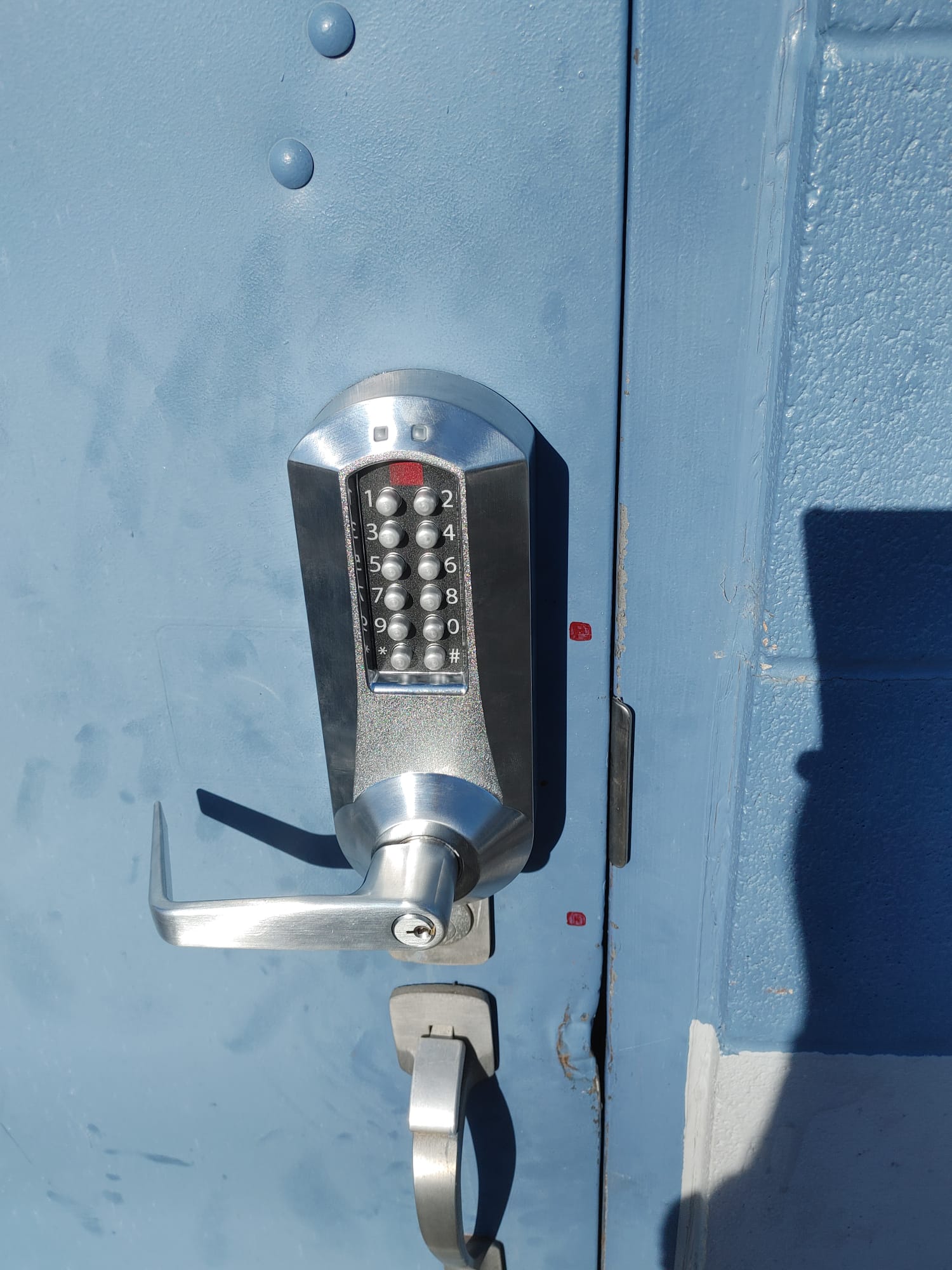 Mechanical pushbutton lever lock on a blue door