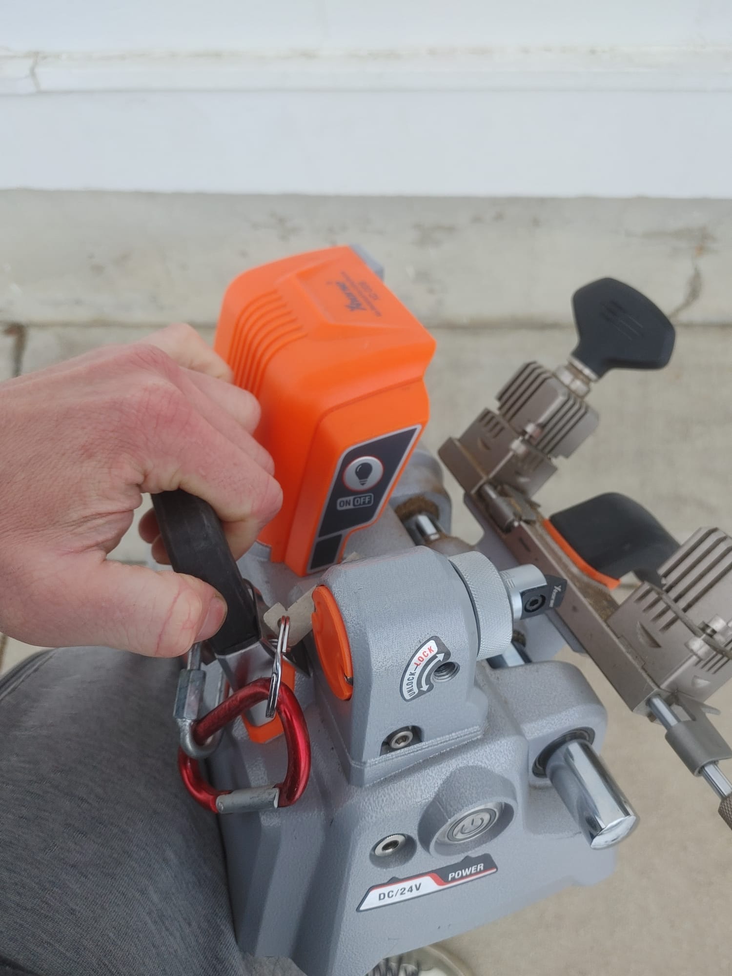 Portable battery-powered key cutting machine in use on the truck