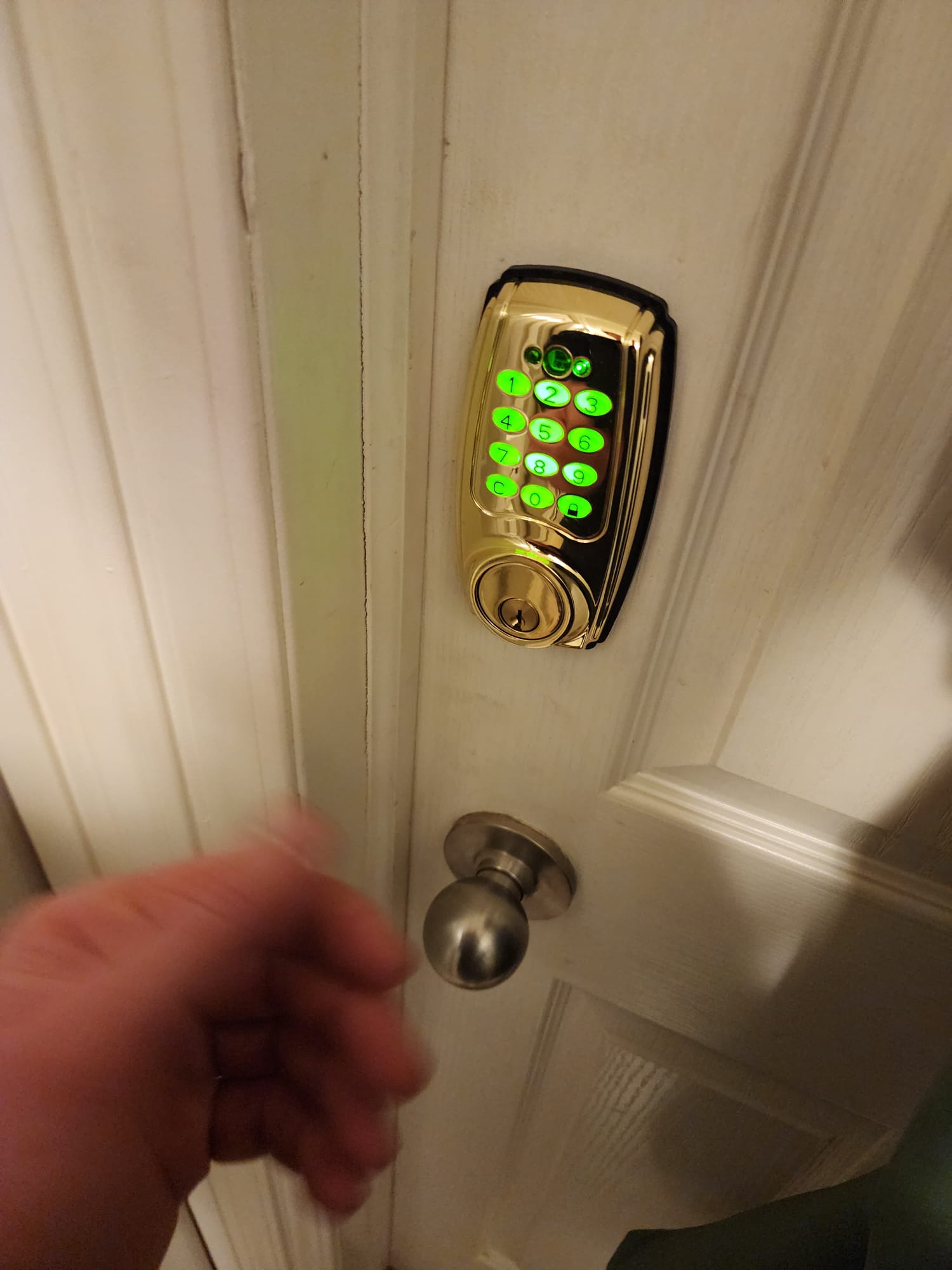 Brass keypad deadbolt with green illuminated keys