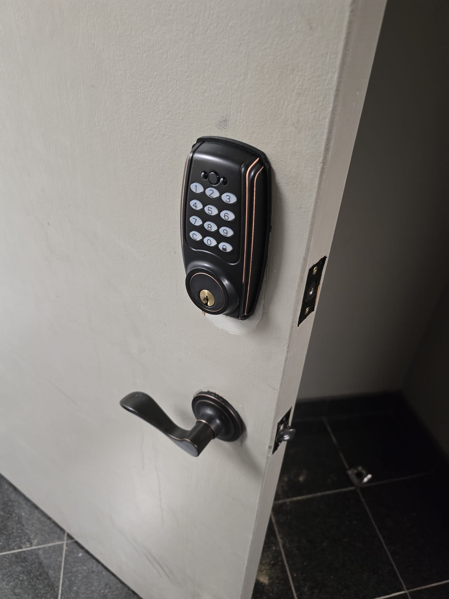 Electronic keypad deadbolt installed on a white door