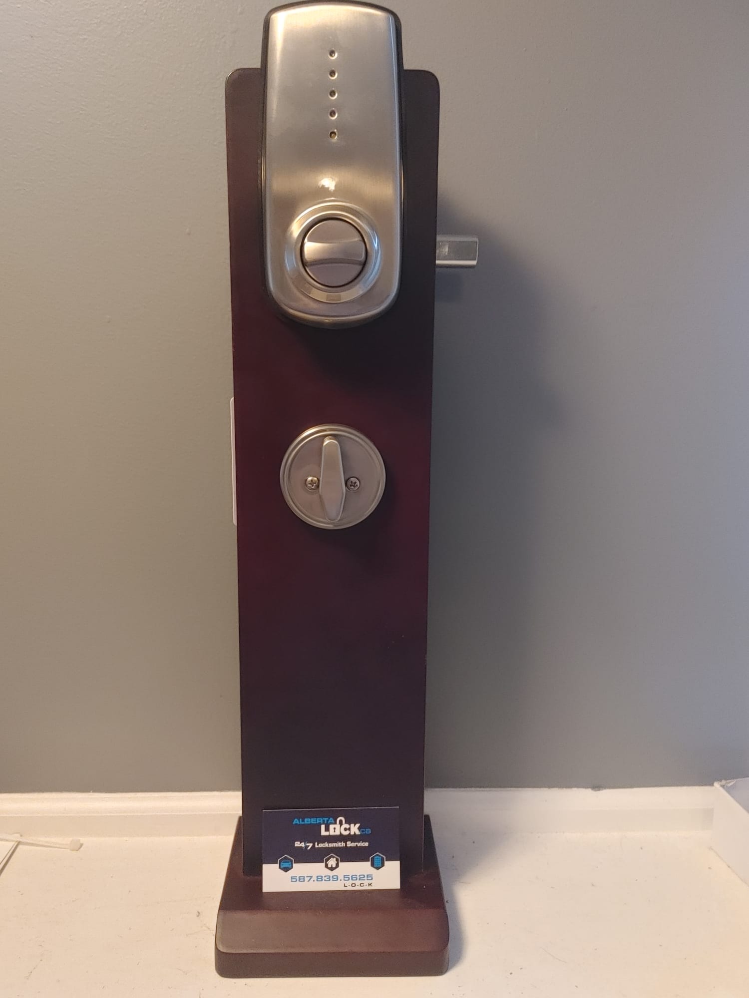LSDA electronic deadbolt on a display stand with a business card